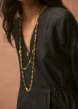 model wearing dangling 18kt Gold Vermeil Afghanistan Zarmina Seed Long Chain Necklace layered with two necklaces