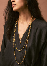 model wearing 18kt Gold Vermeil Afghanistan Zarmina Seed Long Chain Necklace layered with two necklaces